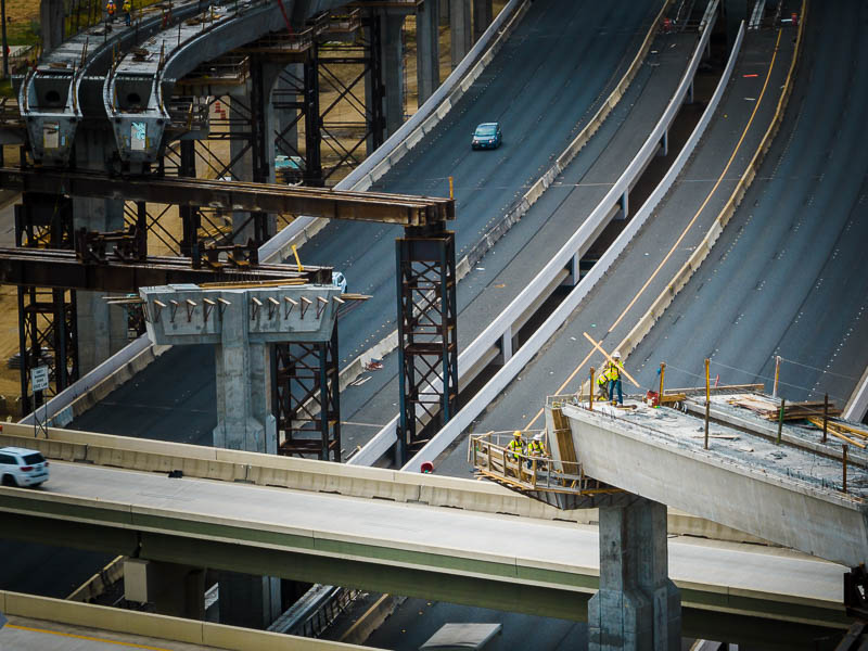 Drone aerial photo of road construction worker on bridge in Houston, Texas.